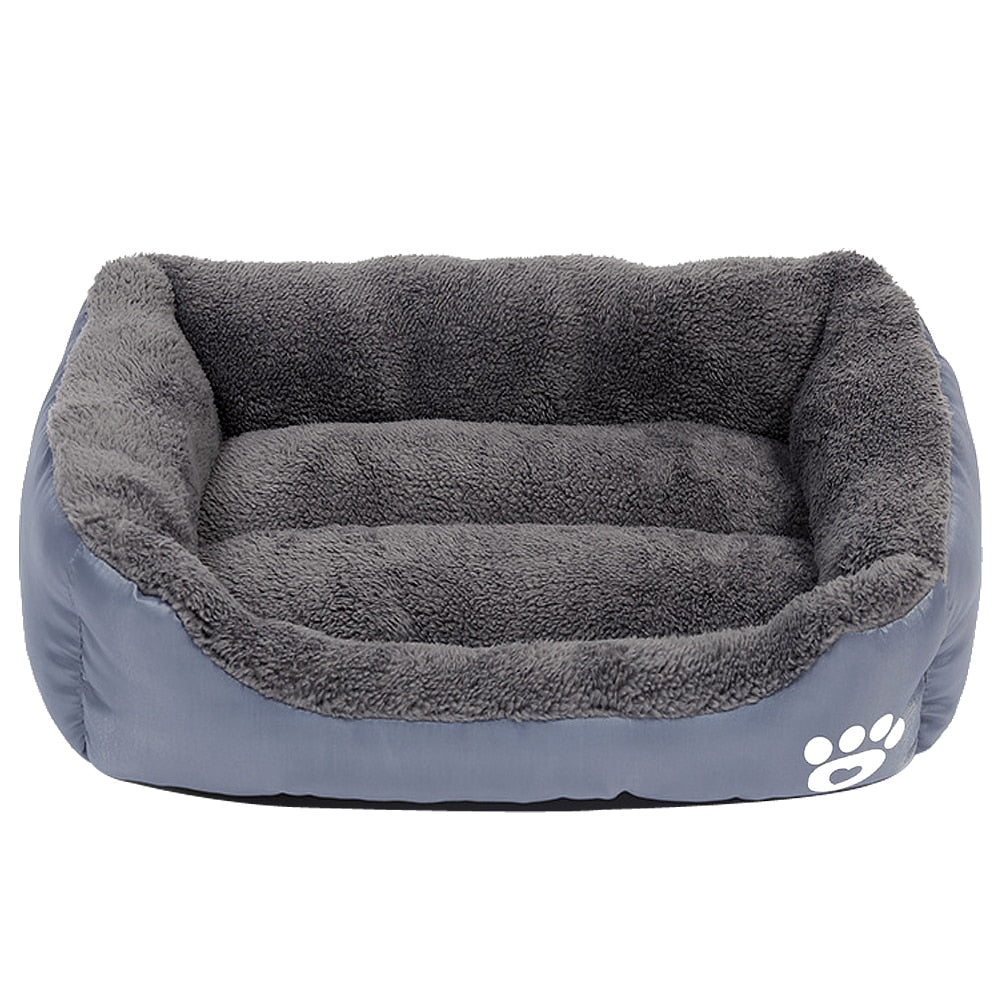 An Anything Pets gray dog bed with a paw print on it.